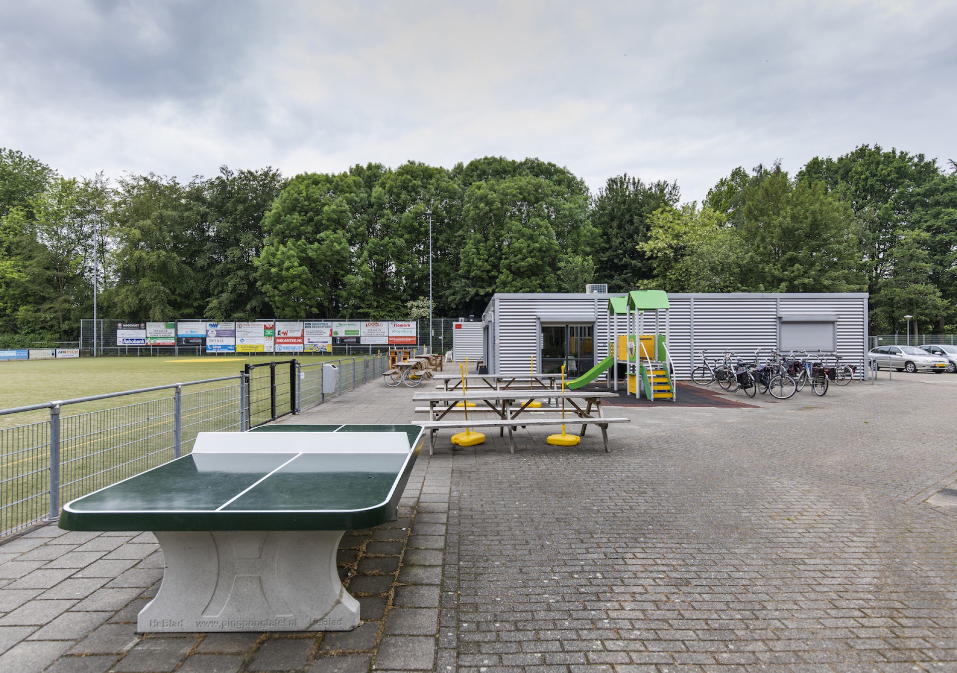 Nog even een potje tafeltennis terwijl kinderen zich vermaken op het speeltoestel